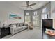 Cozy living room featuring a comfortable gray sofa, recliner, ceiling fan, and ample natural light from multiple windows at 1102 Emerald Dunes Dr, Sun City Center, FL 33573