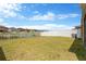 Spacious backyard featuring a large lawn and partial fence overlooking other homes at 1210 Trailwater St, Ruskin, FL 33570
