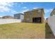 Wide view of the large backyard with a well-maintained lawn, privacy fence and the back of the house at 1210 Trailwater St, Ruskin, FL 33570