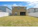 Wide view of the large backyard with a well-maintained lawn, privacy fence and the back of the house at 1210 Trailwater St, Ruskin, FL 33570