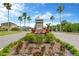 Community entrance featuring lush landscaping and a decorative sign with palm trees at 1210 Trailwater St, Ruskin, FL 33570
