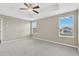 Bright main bedroom featuring a tray ceiling, neutral paint, and carpet flooring with two windows bringing in natural light at 1210 Trailwater St, Ruskin, FL 33570