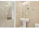 Well-lit powder room with pedestal sink, oval mirror, and views of the entry and stairway at 1210 Trailwater St, Ruskin, FL 33570