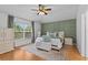 Bright main bedroom boasts a neutral palette with a green accent wall and a big window overlooking nature at 1216 Bensbrooke Dr, Wesley Chapel, FL 33543