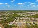 Expansive aerial view showcasing a community with lush greenery, well-maintained homes, and a clear blue sky at 13096 Linzia Ln, Spring Hill, FL 34609