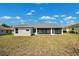 View of the home's backyard featuring the covered lanai, and green space at 13096 Linzia Ln, Spring Hill, FL 34609