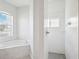 The bathroom features a soaking tub next to a window and a separate glass-enclosed shower with marble-look tile at 13096 Linzia Ln, Spring Hill, FL 34609