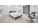 Bright bedroom with a gray upholstered bed frame, light carpet, and modern gray curtains at 13096 Linzia Ln, Spring Hill, FL 34609