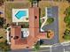 Aerial view of a clubhouse with a pool, outdoor seating, manicured landscaping, and ample parking at 13096 Linzia Ln, Spring Hill, FL 34609