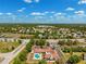Aerial view of community amenities: pool, clubhouse, parking, and beautiful landscaping at 13096 Linzia Ln, Spring Hill, FL 34609