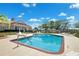 Community pool surrounded by lounge chairs, community center in the background at 13096 Linzia Ln, Spring Hill, FL 34609