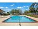 Community pool surrounded by lounge chairs, with playground in the background at 13096 Linzia Ln, Spring Hill, FL 34609