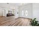 Bright foyer with stylish front doors, wood floors, and view into the living space with leather sofa and arched doorway at 13096 Linzia Ln, Spring Hill, FL 34609