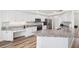 Modern kitchen with an island featuring stainless steel appliances, granite countertops, and wood floors at 13096 Linzia Ln, Spring Hill, FL 34609