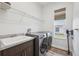 Laundry room featuring modern washer and dryer, sink, and overhead shelving at 13096 Linzia Ln, Spring Hill, FL 34609