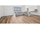Bright open living room area featuring luxury vinyl flooring, a large window, and a comfortable gray sectional sofa at 13096 Linzia Ln, Spring Hill, FL 34609