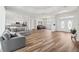 Open-concept living area with wood floors, neutral gray sofa, and seamless flow into the kitchen and dining spaces at 13096 Linzia Ln, Spring Hill, FL 34609