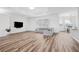 Bright living room with hardwood floors, gray sectional sofa, and a large screen television at 13096 Linzia Ln, Spring Hill, FL 34609
