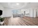 Bright open-concept living area featuring wood floors and easy access to the kitchen, dining, and living spaces at 13096 Linzia Ln, Spring Hill, FL 34609
