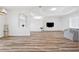 Bright living room with wood floors, tray ceiling, and open layout to the dining and kitchen areas at 13096 Linzia Ln, Spring Hill, FL 34609