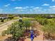 Overhead view of a colorful playground with slides and swings near residential area with trees in the distance at 13096 Linzia Ln, Spring Hill, FL 34609