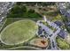 Aerial view of a community park featuring an open green space, playground, and parking at 13821 Kinsale St, Riverview, FL 33579