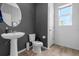 Modern half bath featuring gray walls, a pedestal sink, and stylish black and white wallpaper at 13821 Kinsale St, Riverview, FL 33579