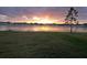 Picturesque lake view reflecting a beautiful sunset, enhancing the serene backyard scenery with lush green grass at 13821 Kinsale St, Riverview, FL 33579