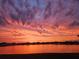 Picturesque lake reflecting vibrant orange and pink sunset skies, highlighting the serene backyard scenery at 13821 Kinsale St, Riverview, FL 33579