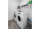 Efficient laundry room with front load washer and dryer and sleek tile flooring at 13821 Kinsale St, Riverview, FL 33579