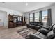 Open living room featuring a large entertainment center, black leather couches, and plenty of natural light at 13821 Kinsale St, Riverview, FL 33579