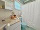 Retro bathroom featuring blue toilet, shower, and unique nautical wallpaper at 14006 79Th Ave, Seminole, FL 33776