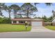Charming single-story brick home featuring a two-car garage, manicured lawn, and mature trees at 14006 79Th Ave, Seminole, FL 33776