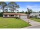 Charming single-story home with a well-maintained lawn, brick accents, and attached garage at 14006 79Th Ave, Seminole, FL 33776