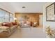 Comfortable living room with wood-paneled wall, plush seating, and neutral carpet, creating a cozy atmosphere at 14006 79Th Ave, Seminole, FL 33776