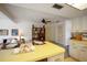 Open-concept living room features yellow kitchen counter, cozy seating, and built-in wooden shelves at 14006 79Th Ave, Seminole, FL 33776