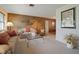 Inviting living room featuring neutral carpet, plush seating, bright natural lighting and a wood-paneled wall at 14006 79Th Ave, Seminole, FL 33776