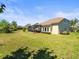 Sprawling backyard view featuring home's lanai, lush lawn, and lovely landscaping at 14209 Quintessa Ln, Lithia, FL 33547