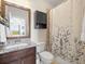 Bathroom featuring a granite vanity top, dark wood cabinets, and a shower-tub combo at 14209 Quintessa Ln, Lithia, FL 33547