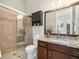 Bathroom with granite counter, dark wood cabinets, tile shower, and glass door at 14209 Quintessa Ln, Lithia, FL 33547