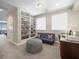 Comfortable bedroom with built-in bookshelves, a cozy sofa, and ample natural light from two bright windows at 14209 Quintessa Ln, Lithia, FL 33547