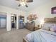 Bright bedroom showcasing a queen-sized bed, neutral decor, and a connecting bathroom at 14209 Quintessa Ln, Lithia, FL 33547
