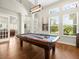 Well-lit game room features a pool table, decorative lighting and large windows overlooking the front yard at 14209 Quintessa Ln, Lithia, FL 33547