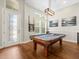Spacious game room featuring a pool table, wood flooring, and decorative lighting at 14209 Quintessa Ln, Lithia, FL 33547