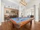 Spacious game room with a pool table, featuring high ceilings, wood flooring, and custom wood wall at 14209 Quintessa Ln, Lithia, FL 33547