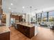 Bright kitchen open to living area with stainless steel appliances, large island, and hardwood floors at 14209 Quintessa Ln, Lithia, FL 33547
