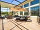 Lovely outdoor lanai featuring dining furniture and lounge seating shaded by a large umbrella at 14209 Quintessa Ln, Lithia, FL 33547