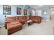 Relaxing living room features a sectional couch, carpeted floors, and natural light from windows at 14209 Quintessa Ln, Lithia, FL 33547