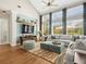 Bright living room with vaulted ceilings, large windows, hardwood floors, and a modern media center at 14209 Quintessa Ln, Lithia, FL 33547