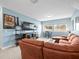 Basement living area offers a comfortable sectional, television, and windows with natural light at 14209 Quintessa Ln, Lithia, FL 33547